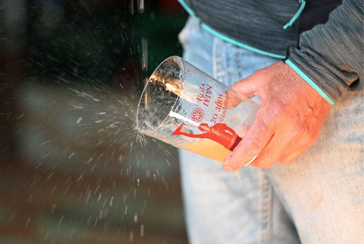 mano escanciando sidra